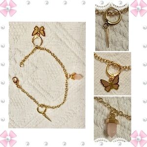 Bracelet - 7.25” gold tone with butterfly, spike and pink Crystal charms.